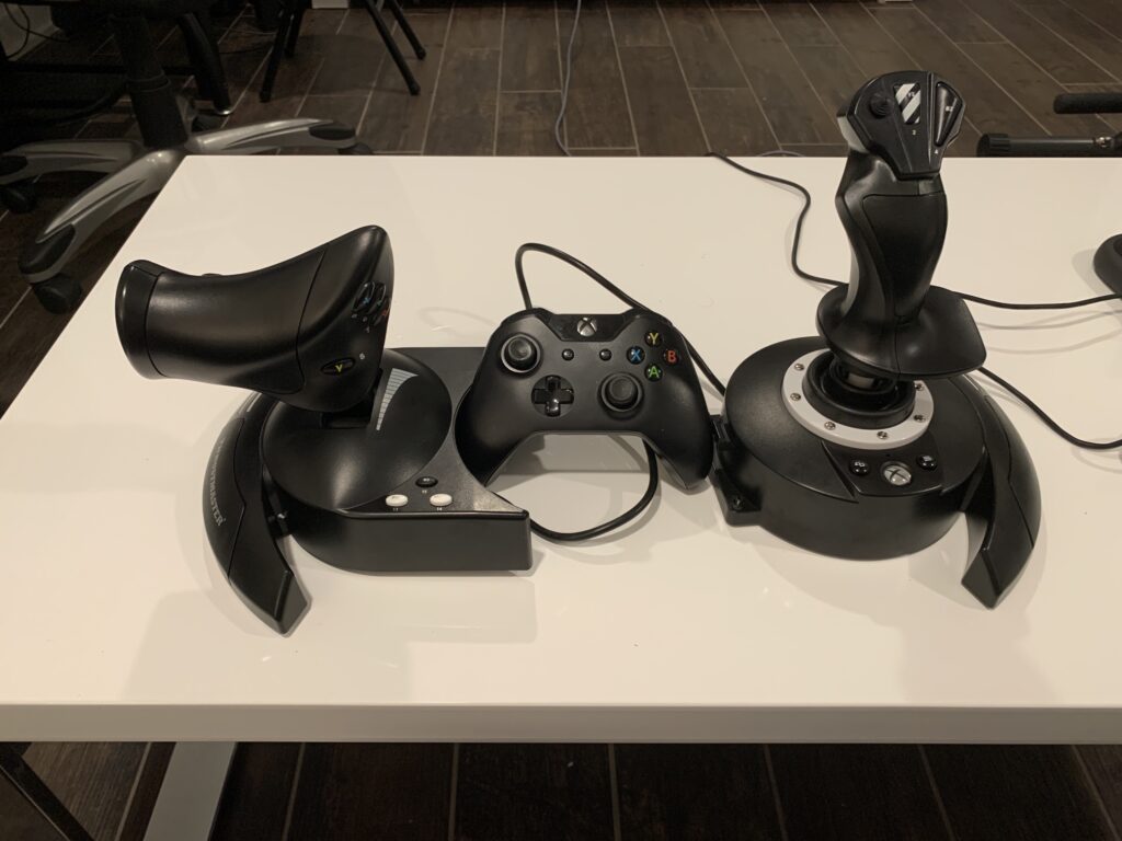 thrust master t-flight hotas one flight stick and throttle unit next to an xbox controller